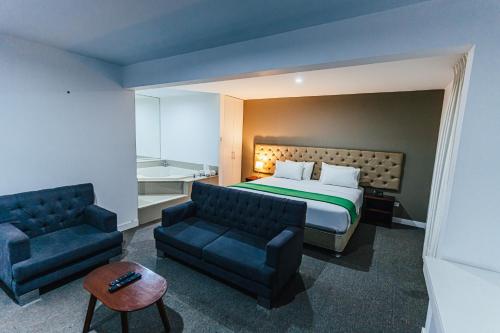 リマにあるHotel Hacienda Lima Norteのベッドとソファ付きのホテルルーム