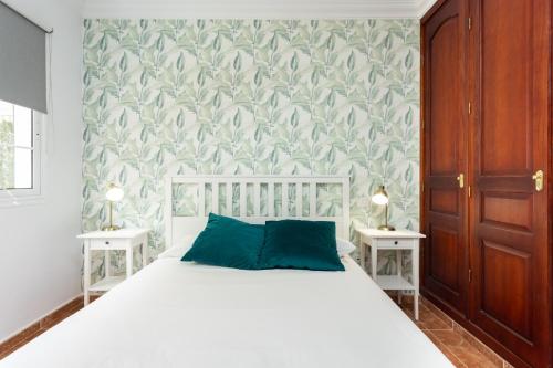 um quarto com uma cama branca e 2 mesas de cabeceira em Apartamento con gran terraza Chill Out em Guía de Isora
