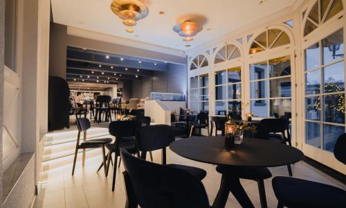a restaurant with tables and chairs and windows at Parkhotel St.Leonhard in Überlingen