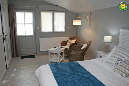 a bedroom with a bed and a chair and a table at Le Clos du miroir in Courset