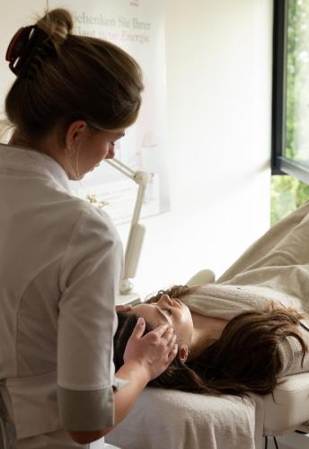 a woman laying on a bed with a woman standing next to at Parkhotel St.Leonhard in Überlingen