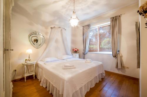 a bedroom with a white bed with a canopy at MF Kormoran Wellness Apartments in Balatonvilágos