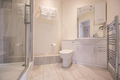 biała łazienka z toaletą i prysznicem w obiekcie Parnell Corner Apartments w Dublinie