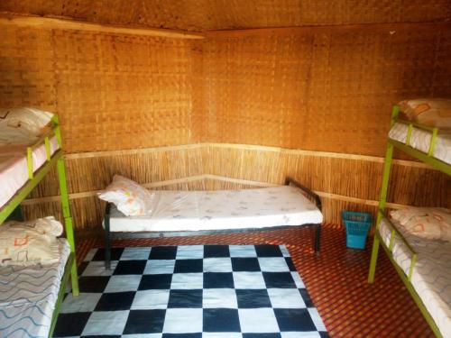 a room with two bunk beds and a checkered floor at Mbunga Community Tourism Campsite in Kasese