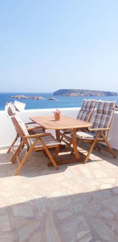 a wooden table and two chairs sitting next to the ocean at Sophia & Chris Studios in Santa Maria