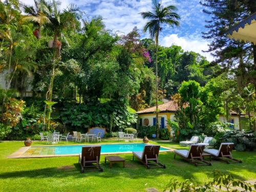 a house with a swimming pool in a yard at Pousada Vila Brasil in Petrópolis