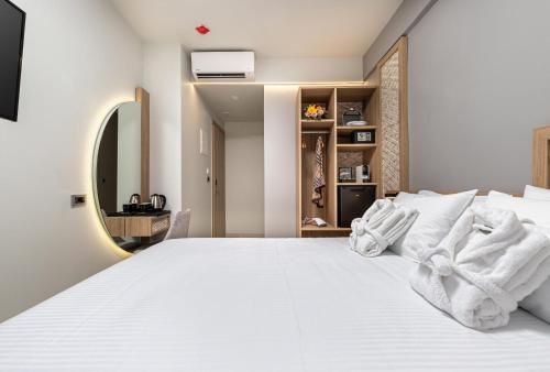 een slaapkamer met een wit bed en een spiegel bij Metropolitan Pearl Boutique Hotel in Chania