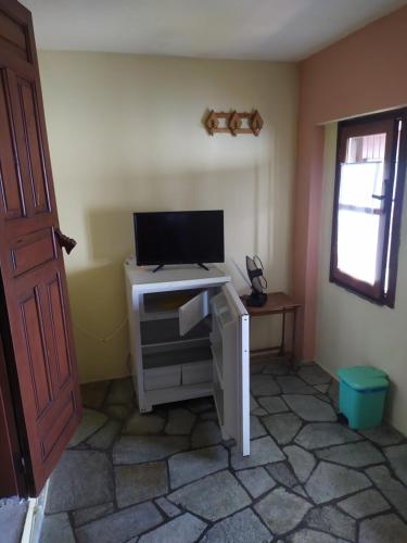 a room with a tv on top of a desk at Double studio room in front of the sea in Tsagarada