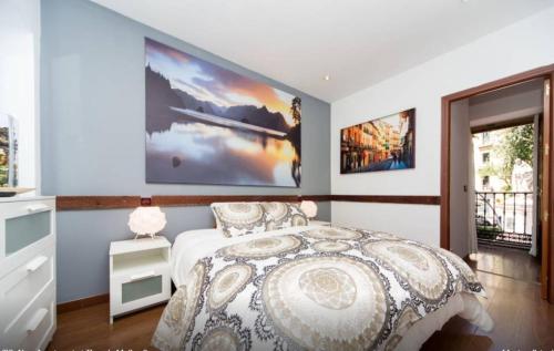 Un dormitorio con una cama y dos cuadros en la pared. en Sol - 5 Tirso de Molina - ALQUILER CORTA ESTANCIA, en Madrid