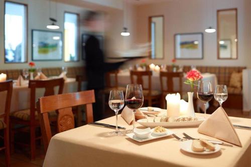 una mesa en un restaurante con copas de vino en Hotel Akazienhaus, en Herzogenaurach