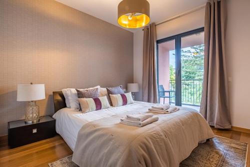 1 dormitorio con 1 cama grande y toallas. en Living Funchal by Madeira Sun Travel, en Funchal