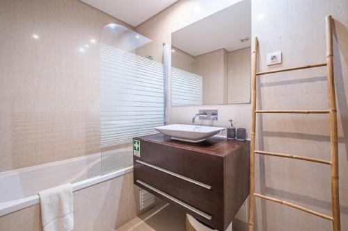uma casa de banho com um lavatório, um chuveiro e uma banheira em Living Funchal by Madeira Sun Travel em Funchal