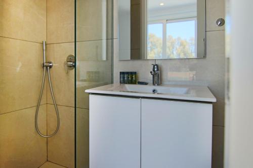 a bathroom with a white sink and a shower at Phaedrus Living - Seaside Deluxe Flat Harbour 112 in Paphos