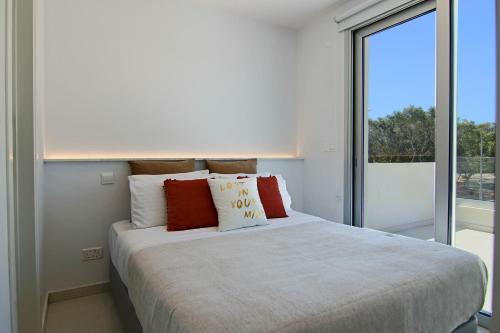 Phaedrus Living - Seaside Deluxe Flat Harbour 112 في Paphos: غرفة نوم بسرير كبير مع نافذة كبيرة