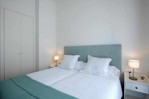 una camera da letto con un grande letto bianco con due lampade di Mike House Alójate en el corazón de Zaragoza a Saragozza