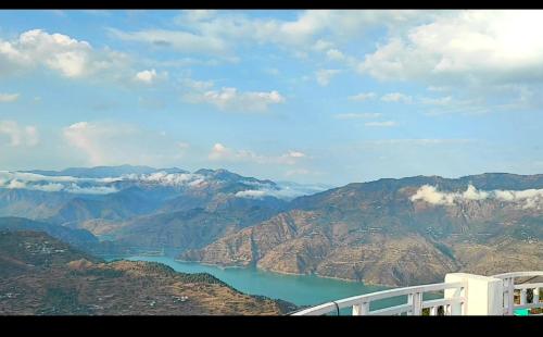 a view of a lake in the middle of mountains at Hotel Shiv Palace in Tehri-Garhwāl