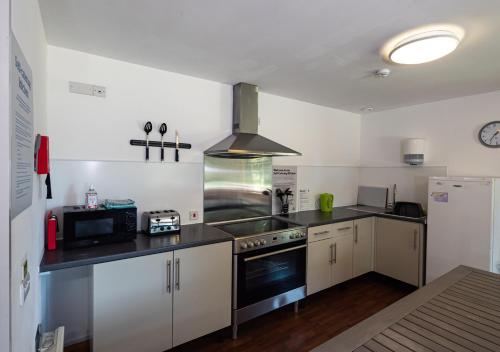 a kitchen with a stove and a refrigerator at YHA London Lee Valley in Cheshunt