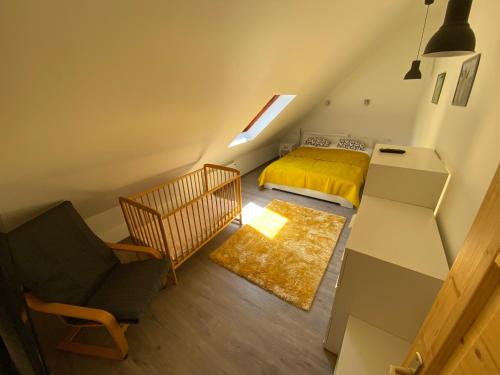 Dormitorio pequeño en el ático con cama y silla en HUTA-TÚRA 42 Vendégház, en Háromhuta