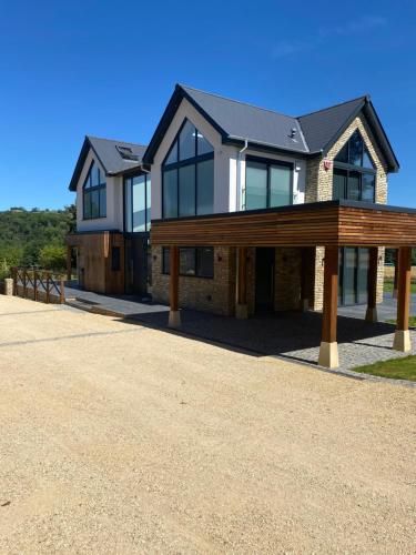 una casa su una strada sterrata con un vialetto di Stunning modern home set in beautiful grounds. a Bath