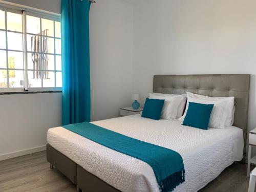 1 dormitorio con 1 cama grande con detalles en azul en Vilabranco en Albufeira