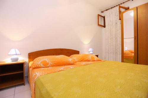 a bedroom with a bed and two lamps and a mirror at Apartments by the sea Poljica, Trogir - 10353 in Marina