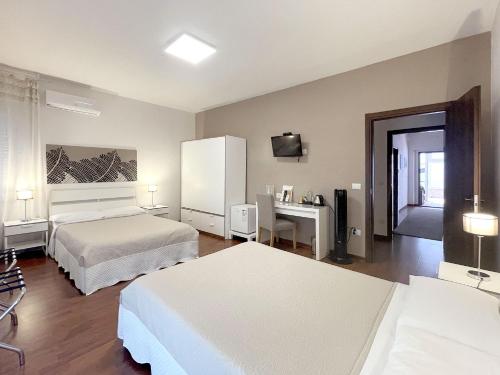 a hotel room with two beds and a desk at B&B Villa Paradiso in Urbino