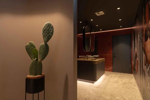 a bathroom with a cactus next to a sink at LOEV - VELA Hotels in Binz