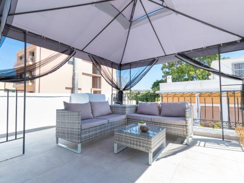 a patio with two couches and an umbrella at Metropolitan Pearl Boutique Hotel in Chania Town
