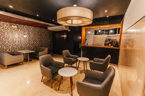a waiting room with tables and chairs and a counter at Hotel Hacienda Lima Norte in Lima
