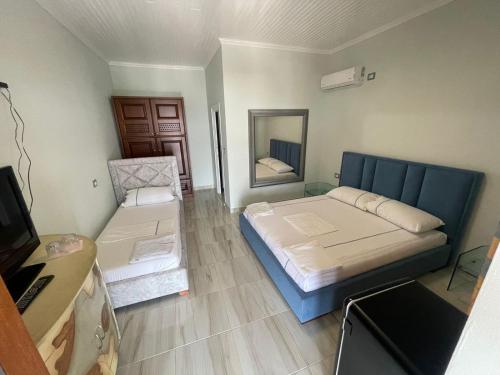 a small bedroom with a bed and a mirror at Paolo's Apartaments in Himare