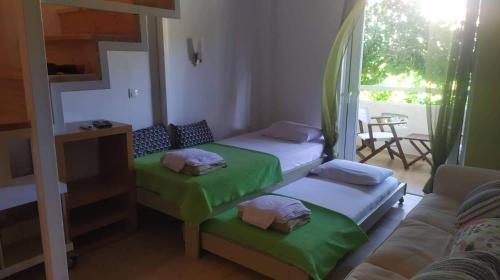ein Wohnzimmer mit 2 Betten und einem Sofa in der Unterkunft Eleonas Studios in Poros