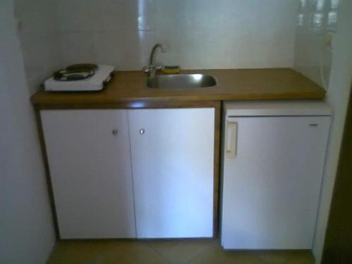 cocina con fregadero y encimera con armarios en La Cite Family Hotel & Apartments en Moraitika