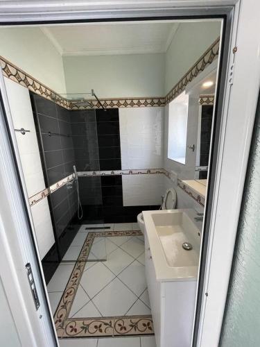 a bathroom with a toilet and a sink and a mirror at Paolo's Apartaments in Himare