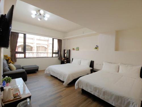 a hotel room with two beds and a couch at JINGTONGYULI BnB 民宿編號2415 in Yuli