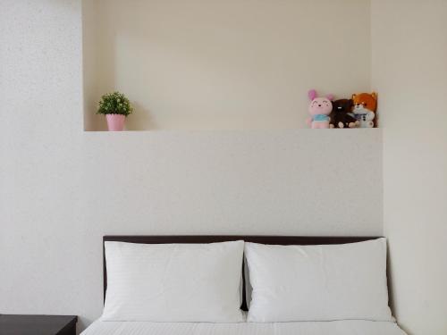 a shelf above a bed with stuffed animals on it at JINGTONGYULI BnB 民宿編號2415 in Yuli