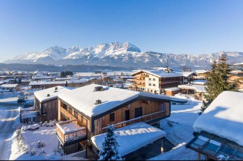 a town covered in snow with mountains in the background at Hotel Penzinghof in Oberndorf in Tirol