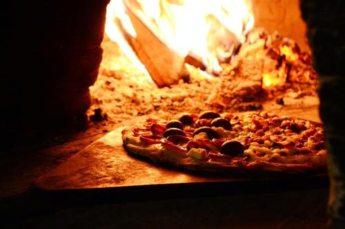 uma pizza está sentada num forno a lenha em Ingerichte de Waard tent voor 2 personen em Zwiggelte