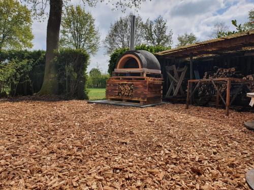 een houtkachel in een tuin naast een gebouw bij Ingerichte de Waard tent voor 2 personen in Zwiggelte