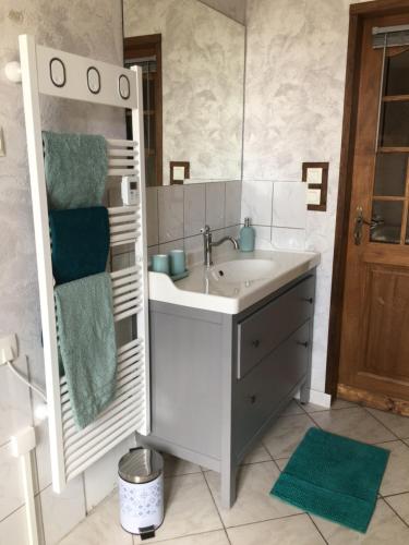 a bathroom with a sink and a mirror at Au Relais de l'Histoire Gîte classé 4 étoiles in Oberbronn