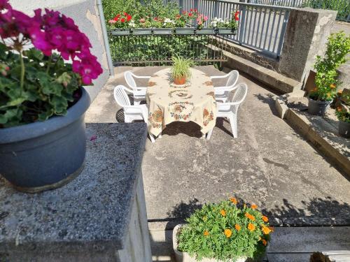 a patio with a table and chairs and flowers at Chambres d'hôtes A la Fecht Nature et Bien-être in Sondernach