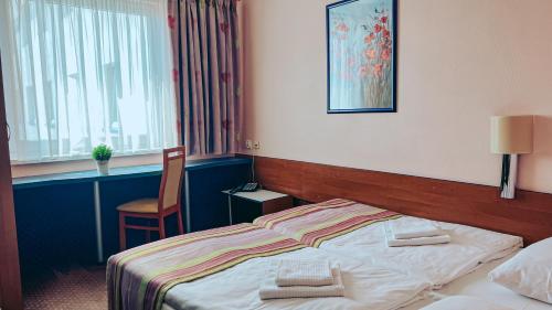 a hotel room with a bed and a chair at Aqua Hotel in Polkowice
