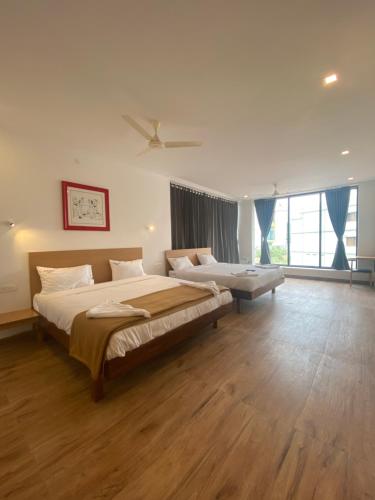 a bedroom with a large bed and a large window at Hotel Bluestone in Srikalahasti