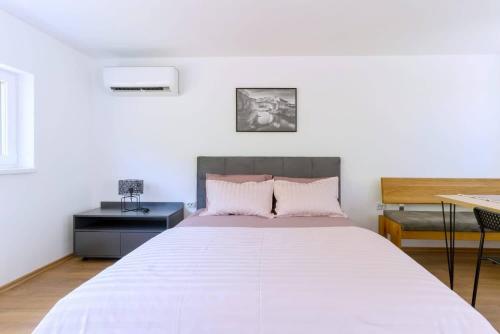 a bedroom with a large white bed in a room at OZ - Obecana Zemlja Permaculture Homestead in Blagaj