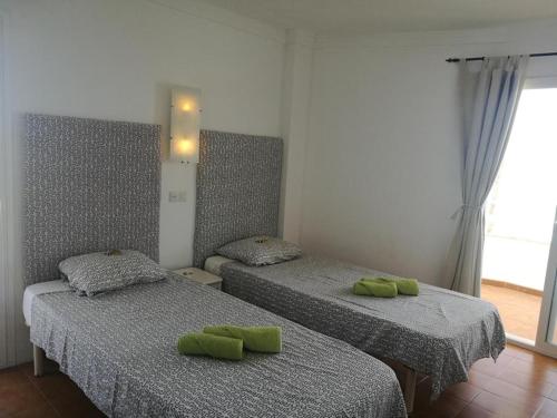 Cette chambre comprend 2 lits avec des oreillers verts. dans l'établissement Meerblick Apartment Sabina, à Cala Millor