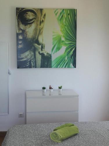 a white bed with a green towel on top of it at Meerblick Apartment Sabina in Cala Millor