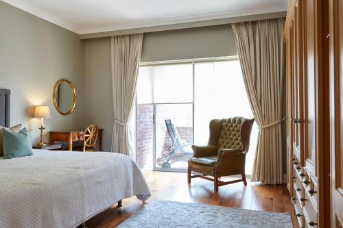 a bedroom with a bed and a chair and a window at 9 Hertford Street in London