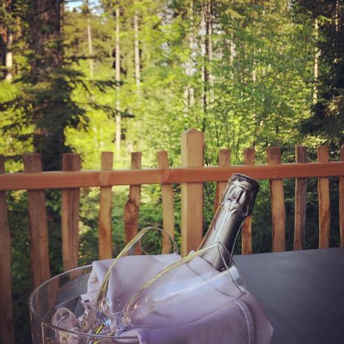 a glass bottle of wine sitting on a table at Les Lodges de Babylone in Larringes