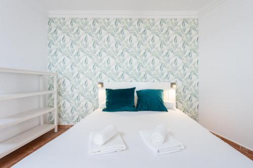 a bedroom with a white bed with blue pillows at Estudio con gran terraza Chill Out in Guía de Isora