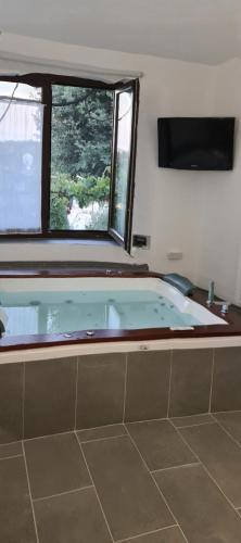 a bath tub in a bathroom with a window at Piccolo Feudo Green Resort in Viterbo
