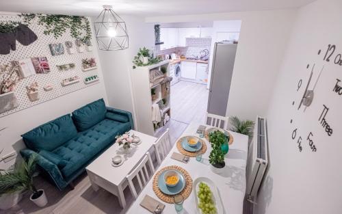 uma sala de estar com um sofá azul e uma mesa em Forest Work & Relax Accommodation em Overstone